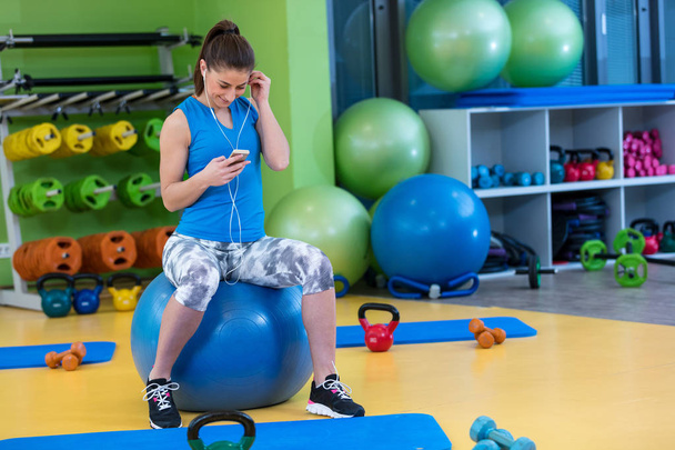 woman using smartphone at gym - Foto, Imagem