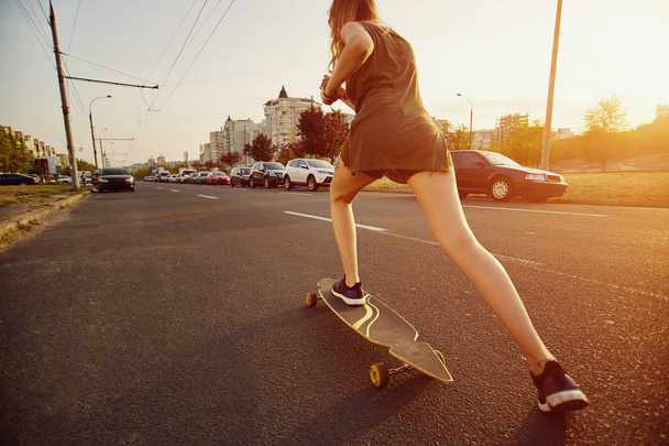 Kaunis nuori tyttö tatuoinnit ratsastus longboard aurinkoisella säällä
 - Valokuva, kuva