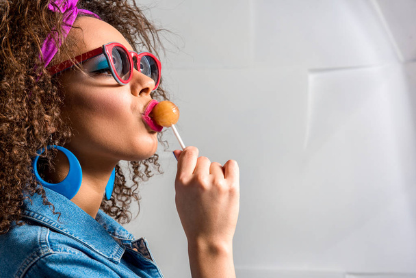 Calm african female eating candy - 写真・画像
