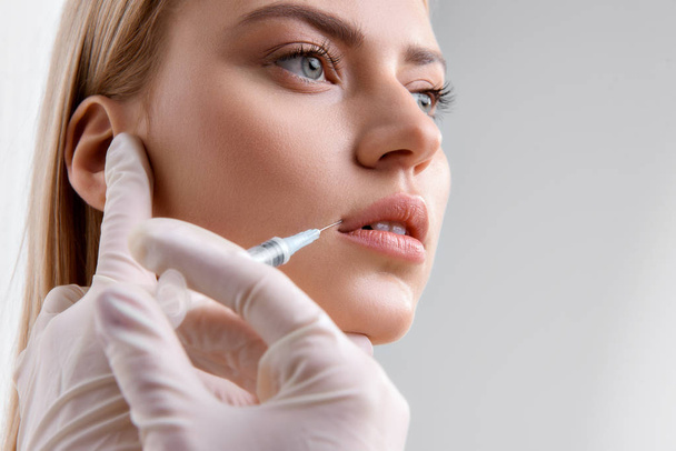 Young lady getting collagen injection - Foto, imagen