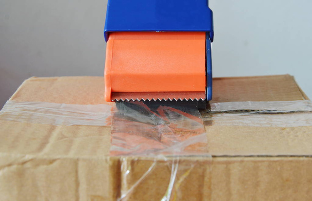 pásky dávkovač těsnění hnědou krabičku na odesílání - Fotografie, Obrázek