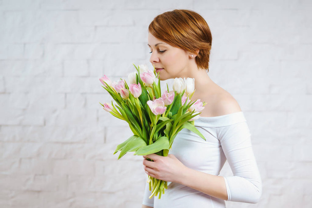 beautiful woman holding a bouquet of tulips - Foto, afbeelding
