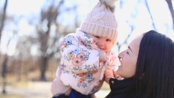 Νέοι ξανθιά μητέρα και το μωρό γελά μαζί, ενώ παίζουν σε εξωτερικούς χώρους - Πλάνα, βίντεο
