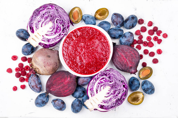 Σμούθις μπολ με μοβ φρούτα και λαχανικά σε άσπρο φόντο. Υγιεινή τροφίμων και διατροφή έννοια - Φωτογραφία, εικόνα