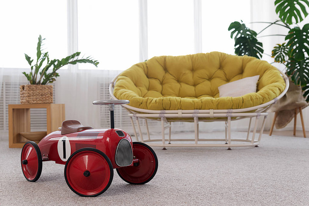 Интерьер комнаты с диваном и игрушечной машиной
 - Фото, изображение
