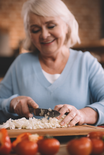 senior woman chopping onions - Zdjęcie, obraz