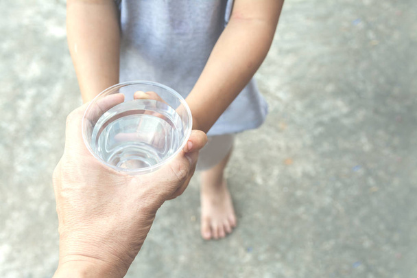 parent hand give fresh water to child hands - Photo, Image