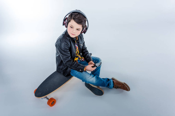 Boy in headphones with skateboard - Фото, зображення