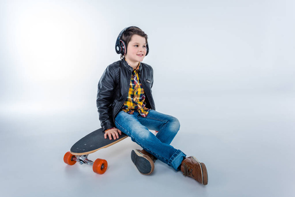Chlapec v sluchátka s skateboard - Fotografie, Obrázek