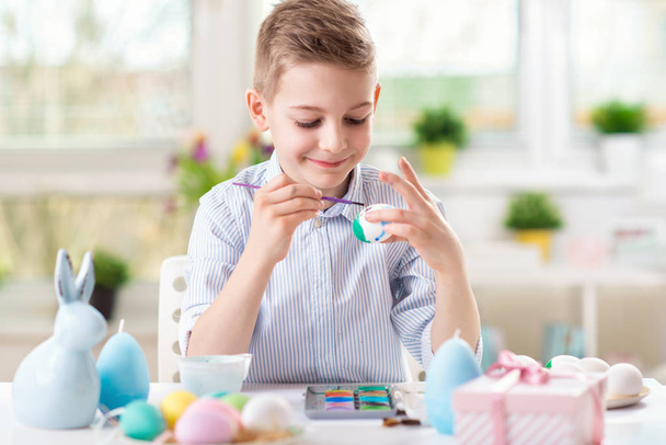 Happy pretty child girl having fun during painting eggs for Easter in spring - 写真・画像