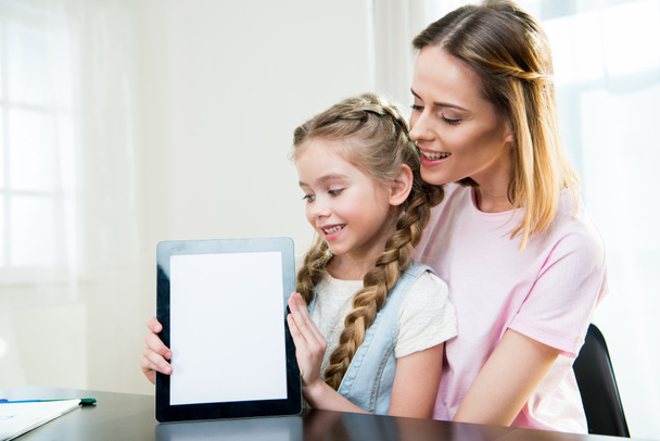 mother and daughter showing digital tablet - Фото, изображение