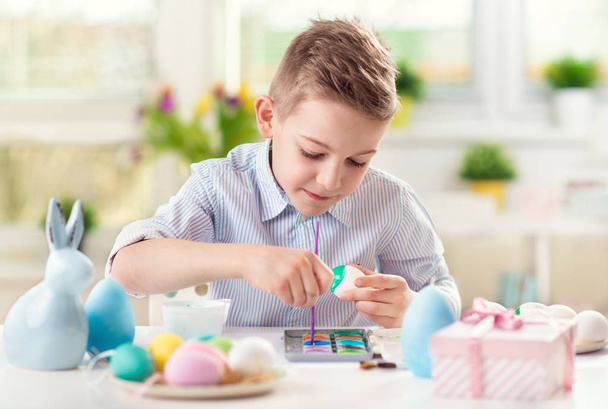 Happy pretty child girl having fun during painting eggs for Easter in spring - Φωτογραφία, εικόνα