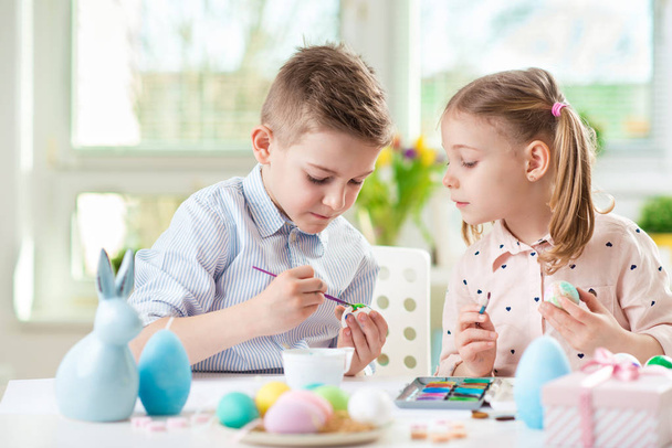 Szczęśliwe dziecko ładny Dziewczyna zabawy podczas malowania jajek na Wielkanoc na wiosnę - Zdjęcie, obraz