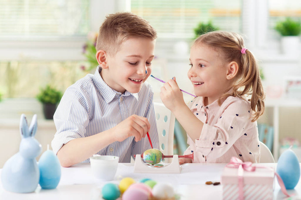 Happy pretty child girl having fun during painting eggs for Easter in spring - Foto, imagen