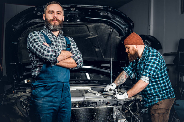 Twee bebaarde mannen een auto repareren - Foto, afbeelding