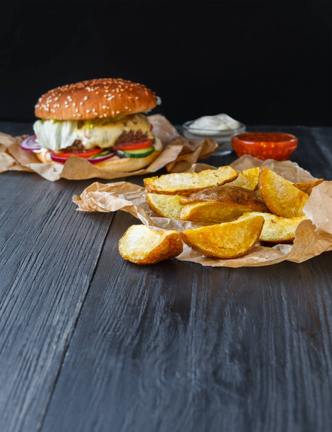 Fast food restaurant dish. Hamburger and fries wedges - Foto, Imagen