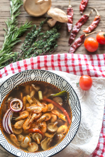 Миска тайського супу томатів на дерев'яному фоні
 - Фото, зображення