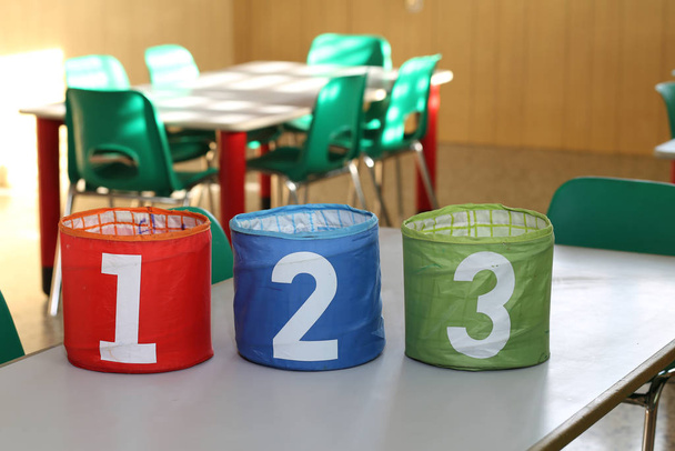 kolme purkkia, joissa on isot numerot yksi kaksi kolme luokkahuoneessa sc
 - Valokuva, kuva