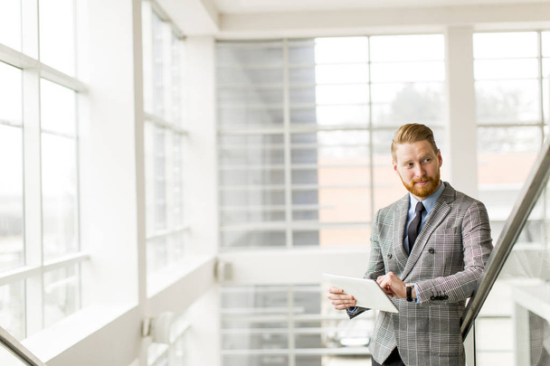 Современный бизнесмен с планшетом в офисе
 - Фото, изображение