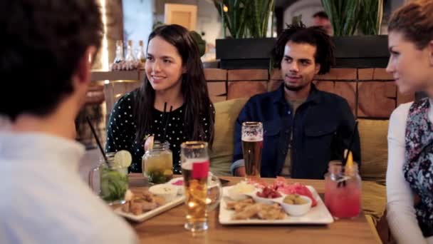 ευτυχείς φίλοι τρώγοντας και πίνοντας στο μπαρ ή στο café - Πλάνα, βίντεο