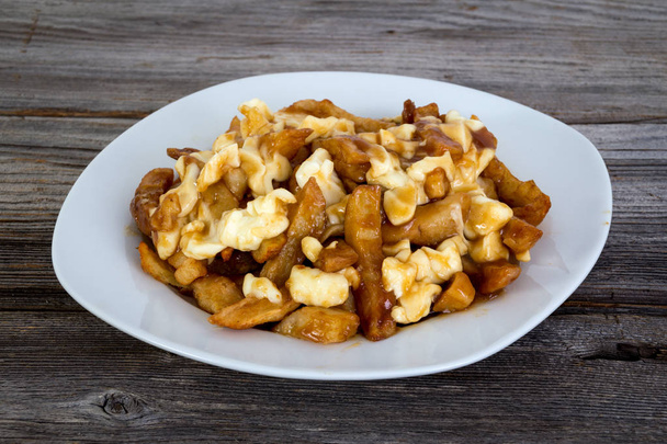 Poutine quebec meal with french fries, svy and cheese curds
 - Фото, изображение