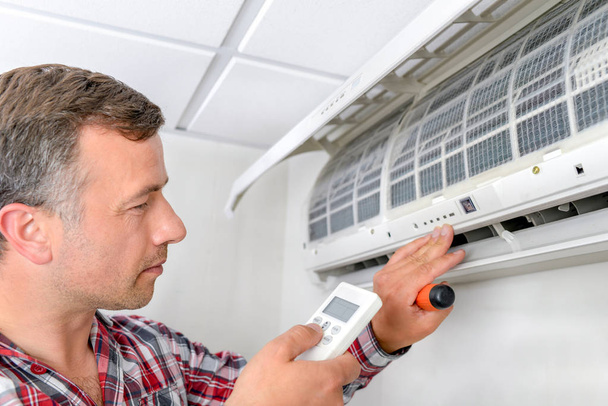 Man checking air conditioning unit - Photo, Image