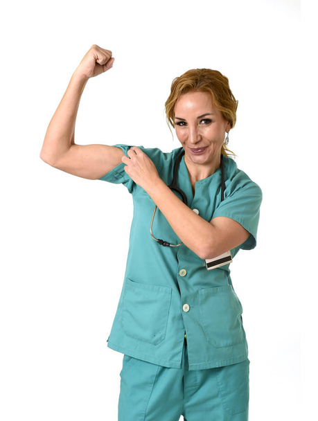 Frau md Notarzt oder Krankenschwester posiert fröhlich lächelnd mit Stethoskop zeigt Bizeps  - Foto, Bild