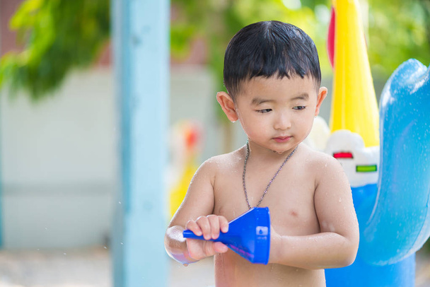 Asian kid playing in inflatable baby swimming pool on hot summer - Zdjęcie, obraz