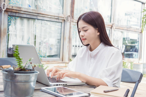 young casual asian woman using technology on her laptop computer - Foto, immagini