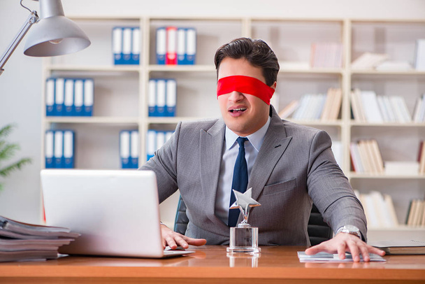 Blinddoek zakenman zit aan bureau in het kantoor - Foto, afbeelding