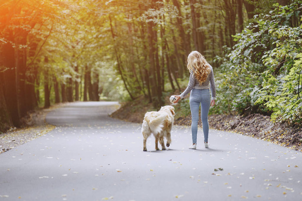 couple walking outdoors with her dog - Φωτογραφία, εικόνα