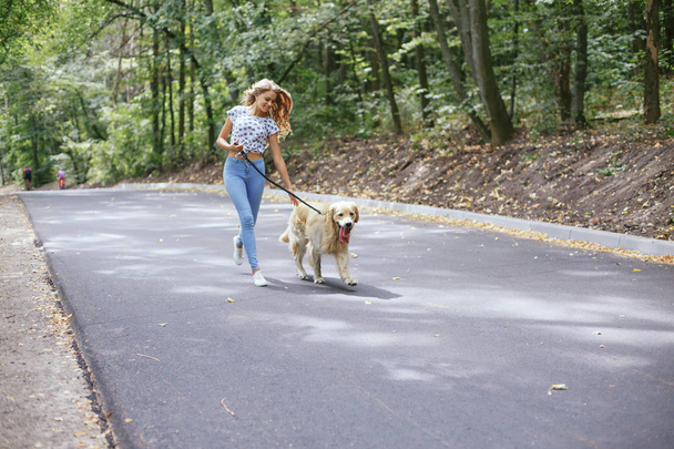 couple walking outdoors with her dog - Φωτογραφία, εικόνα