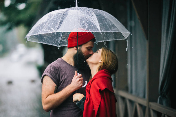 kaveri ja tyttö suudella sateenvarjon alla
 - Valokuva, kuva