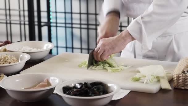 Proseffional chef manos está cortando la col china en su propia cocina moderna en cámara lenta 60fps
 - Metraje, vídeo