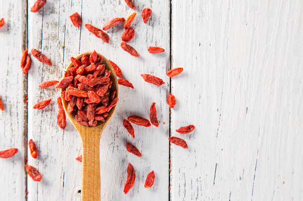 Dry goji berry on old white wooden background. - Photo, image