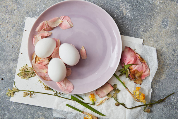 Eggs on plate with petals - Φωτογραφία, εικόνα