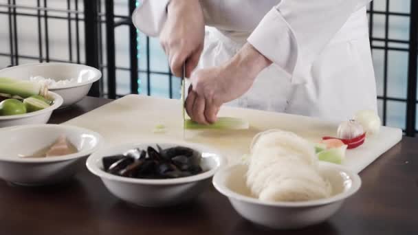 Proseffional manos de chef está cortando apio en su propia cocina moderna en cámara lenta 60fps
 - Metraje, vídeo