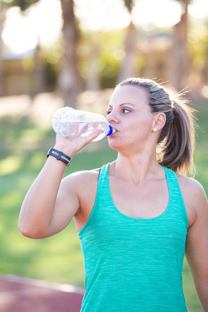  athlete holding out her water bottle - 写真・画像