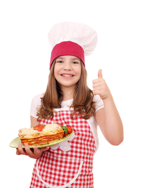 feliz niña cocinero con lasaña italiana y pulgar hacia arriba
 - Foto, imagen