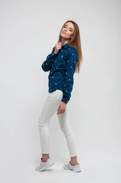 hermosa mujer joven en una camiseta blanca zapatillas de deporte y jeans posi
 - Foto, Imagen