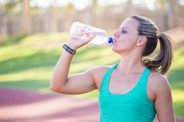  atleta sosteniendo su botella de agua
 - Foto, Imagen