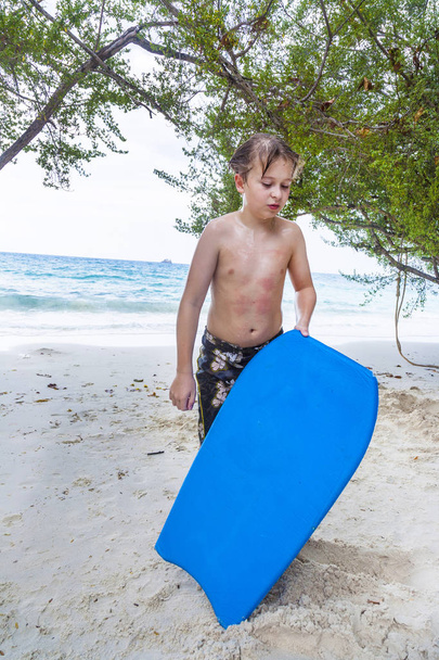 nuori poika rannalla on uupunut surffauksesta
  - Valokuva, kuva