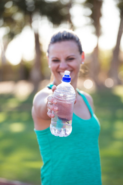  athlete holding out her water bottle - Photo, Image