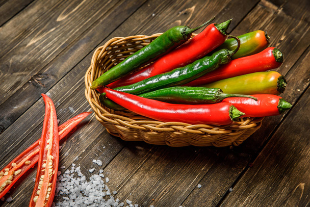 Red and green chili pepper on plate on wooden background - Foto, Imagem