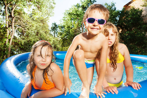 Happy kids playing in swimming pool - Фото, изображение