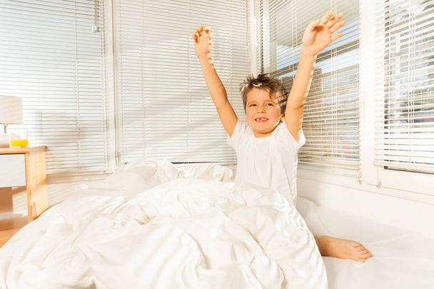 little boy raising hands up in bed - Foto, Imagem