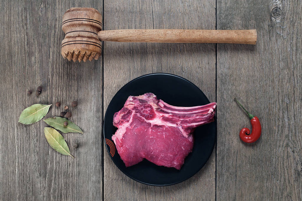 piece of beef with bone, spices and a hammer for meat - Foto, Imagem