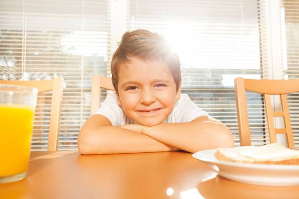маленький хлопчик сидить на кухні і посміхається
 - Фото, зображення