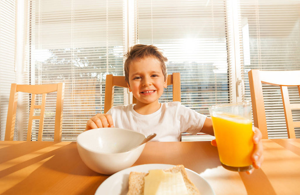 boy eating cereals and drinking juice - Фото, зображення