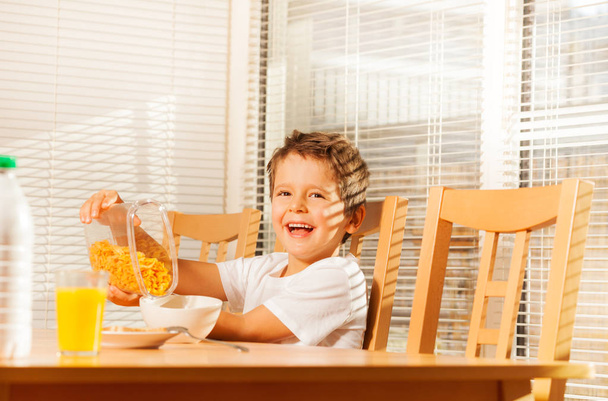 boy pouring corn flakes into bowl - Photo, image